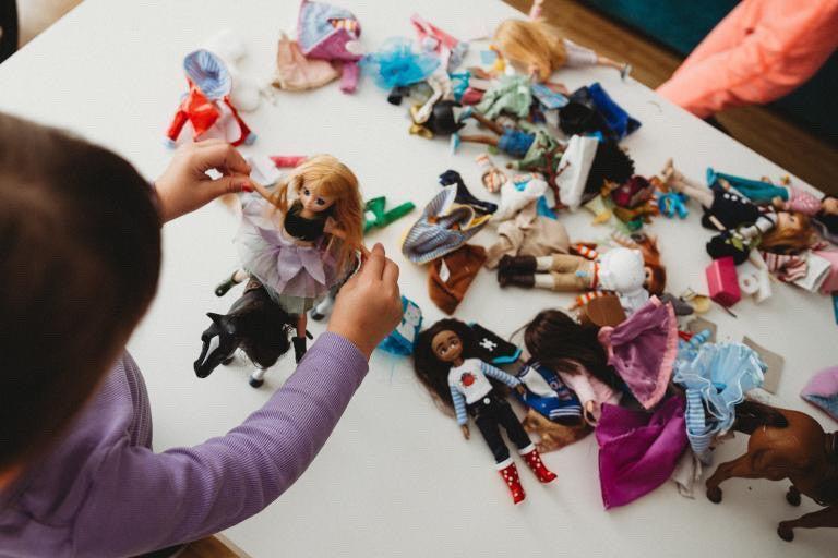 Child playing with dolls and action figures